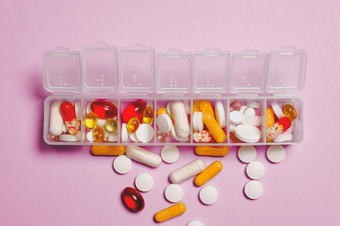 A weekly pill organiser filled with various medicines and supplements, illustrating the importance of managing magnesium interactions for supplement safety