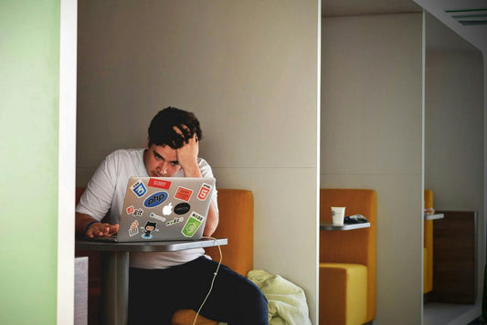 A male programmer looking stressed, a visual representation of fatigue and burnout which can be symptoms of a magnesium deficiency