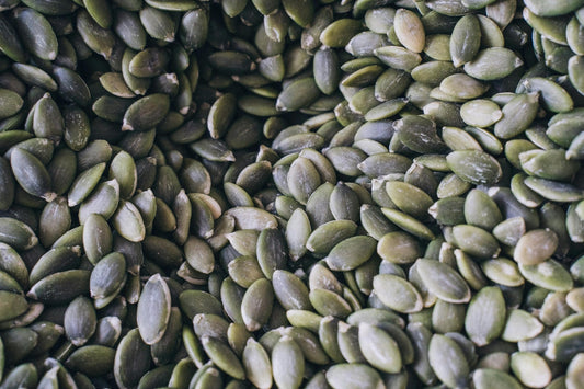  pumpkin seeds scattered across a surface – natural magnesium-rich food source and one of the top foods high in magnesium