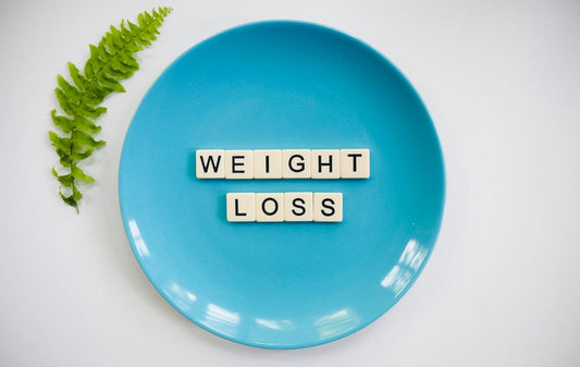 Blue plate with "Weight loss" letters – symbolising resveratrol’s impact on fat metabolism and weight control